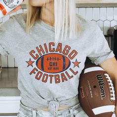 Get ready for game day with this old school Chicago football crewneck. Perfect for Bears football fans, this 90s Bears football shirt makes an ideal Bears football gift. Great chi fans gear and Sunday football wear. Hello there! 😊👋 If you're on the hunt for some seriously cozy T-shirts, you've come to the right place! I'm absolutely passionate about what I do, and my mission is to make your shopping experience absolutely perfect. If you ever have any questions, concerns, or just want to chat a Varsity T-shirt With Team Logo For Football Season, Varsity Football Season Fan Gear T-shirt, Varsity Style T-shirt For Football Season Fan Gear, Varsity Style T-shirt For Football Season, Collegiate Tops For Football Season Tailgating, Collegiate Tops For Tailgating During Football Season, Varsity T-shirt For Football Season Sports Events, Football Season Team Logo T-shirt, Football Season T-shirt With Team Logo