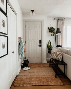 a living room filled with furniture and pictures hanging on the wall next to a door