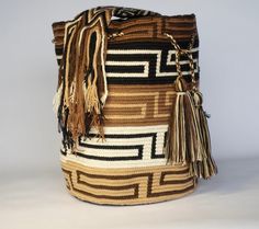 Mochila purse made by artisans of the Wayuu Indigenous Group in Colombia Purchased directly from Artisan, on a Fair Trade Basis Fully Handmade For each Wayuu Mochila Bag purchased, Hands of Colombia donates thread to Indigenous Artisans. Only ONE available Add a touch of indigenous craftsmanship to your style with our Escalonaoqui Wayuu Mochila Purse. Each purse is meticulously handmade by skilled artisans from the Wayuu Indigenous Group in Colombia. Hands of Colombia purchases each item in our Traditional Brown Woven Bucket Bag, Traditional Beige Rectangular Bucket Bag, Traditional Brown Handwoven Bucket Bag, Brown Handwoven Artisan Bucket Bag, Traditional Handmade Brown Bucket Bag, Brown Artisan Crochet Bag, Artisan Handwoven Brown Bucket Bag, Traditional Brown Crochet Bag With Weaving, Artisan Brown Handwoven Bucket Bag