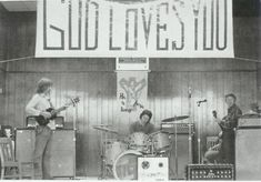 an old black and white photo of some people playing instruments in front of a sign