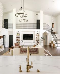 a living room filled with furniture and a fire place under a large chandelier