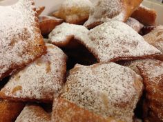 powdered sugar covered pastries in a white bowl