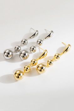 Elevate your style with our 18K Gold-Plated Copper Ball Bead Dangle Earrings, a stunning blend of elegance and durability. Perfect for any occasion, these earrings are designed to add a touch of sophistication to your everyday look. Crafted with precision, the delicate stations adds sophistication. In your choice of Goldstone or Silverstone, you can't go wrong! Whether you’re dressing up for a special event or adding a touch of glam to your everyday attire, these earrings are the perfect accesso Elegant Metal Beaded Earrings With Round Beads, Elegant Round Beaded Metal Earrings, Elegant Round Earrings With Dangling Beads, Elegant Long Drop Beaded Earrings, Elegant Metal Earrings With Dangling Beads, Elegant Metal Beaded Dangle Earrings, Elegant Metal Dangle Beaded Earrings, Elegant Metal Teardrop Earrings With Dangling Beads, Elegant Chandelier Earrings With Round Beads