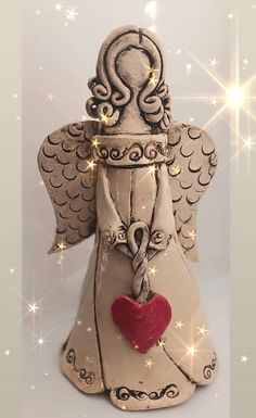 an angel statue with a heart hanging from it's chest