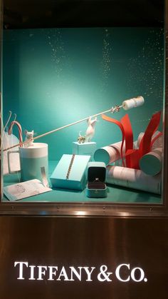 a display case for tiffany & co with various items on the shelf and in front