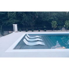 an empty swimming pool surrounded by trees and fence