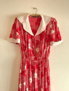 Red and white floral midi dress, made in Portugal in the 1970s by the brand Pulido. Made of silk and viscose. In excellent condition. Cleaning: Hand wash, dry clean, or quick wash without spin cycle on washing machine Dimensions: Height 113cm / 44.5" Shoulder to shoulder width: 40 cm / 15.7" Elastic waist width: 28 to 43 cm / 11" to 16.9" Sleeve length shoulder to cuff: 25 cm / 9.8" GENERAL TERMS AND CONDITIONS: This is an antique / vintage item, any signs of use and aging are natural and visible in the photos, so please look closely. If you have any questions, please feel free to message us before checkout. Knowing that you are satisfied with your purchase is extremely important to us, so please leave your review. PACKAGING TERMS AND CONDITIONS: Whenever possible, we use second hand packa Retro Floral Print Midi Dress For Daywear, Vintage Red Midi Dress For Spring, Red Retro Print Dress For Spring, White Vintage Print Dress, White Vintage Dress With Vintage Print, Red Vintage Midi Dress, White Vintage Floral Midi Dress, White Floral Print Vintage Dress, White Vintage Dress With Retro Print