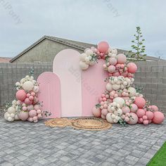 a pink and white wedding arch with balloons