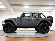 a gray jeep is parked in a large room