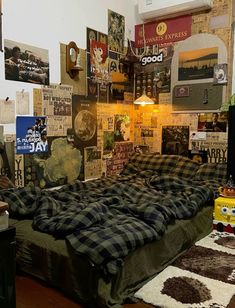 an unmade bed sitting in a bedroom next to a wall covered with pictures and posters