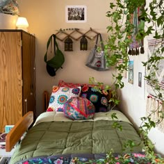 a bed room with a neatly made bed and lots of hanging plants on the wall