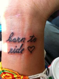 a wrist tattoo with the words born to ride on it