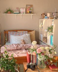 a bed with flowers and books on it in a bedroom next to a book shelf