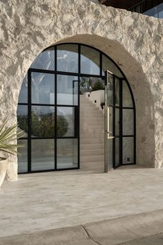 the entrance to a building with an arched glass door and stone steps leading up to it