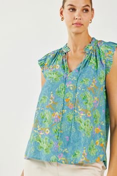 This mood-boosting floral abstract blouse is a bright delight. The popover silhouette has a relaxed silhouette with the sweetest details—ruffle trim, split neckline with a delicate self-tie, and pleated cap sleeves. •Split neckline •Self-tie detailing •Ruffle trim •Pleated cap sleeves with cut edge •Classic fit •Original 'Floral Abstraction' print, designed by Current Air DIMENSIONS •Standard: 24" Length Item number 1930004-5CA 50% recycled polyester 50% Polyester Sleeveless Top With Gathered Neckline For Spring, Summer Floral Print Tie Neck Top, Casual Ruffled Blouse For Garden Party, Summer Garden Party Top With Flutter Sleeves, Summer Garden Party Flutter Sleeve Top, Garden Party Tops With Flutter Sleeves And Floral Print, Flutter Sleeve Ruffle Tops For Garden Party, Green Ruffle Sleeve Top With Floral Print, Green Top With Ruffle Sleeves And Floral Print