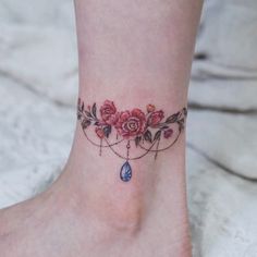 a woman's foot with a flower tattoo on the ankle and a blue tear