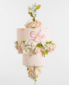 a pink cake decorated with flowers and the word love