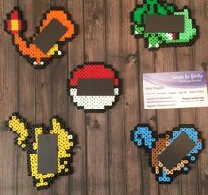 four pixellated nintendo coasters on a wooden table with a business card in front of them