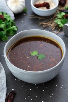 a white bowl filled with soup and garnished with cilantro on the side