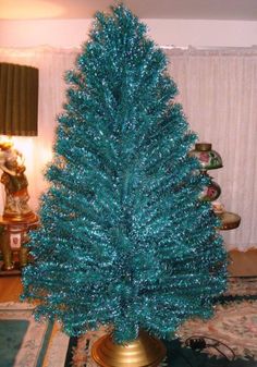 a blue christmas tree in a gold vase