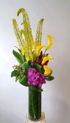 a vase filled with yellow and purple flowers