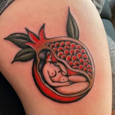 a woman's tattoo on the back of her thigh, with red flowers and leaves