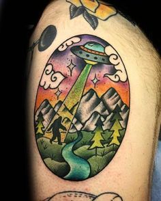 a man with a tattoo on his arm that has an alien ship in the sky