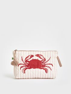 a red crab embroidered on a white striped pouch