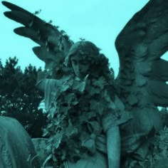 an angel statue surrounded by ivy in a cemetery