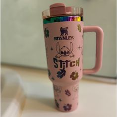 a pink travel mug sitting on top of a white counter with the words stanley stitch printed on it