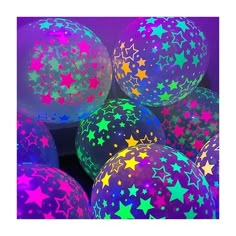 many stars are painted on balloons in purple and green