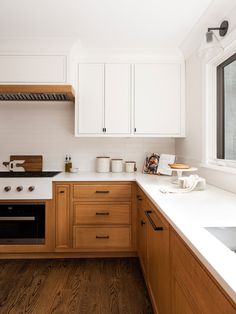 a kitchen with wooden cabinets and white counter tops