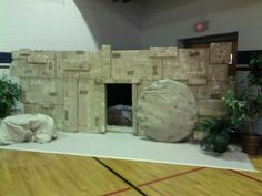 an indoor fireplace made out of cardboard on top of a hard wood floor in a gym