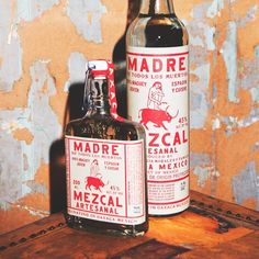 two bottles of alcohol sitting on top of a wooden table