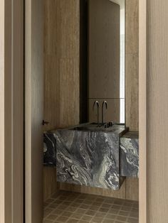 a bathroom sink sitting under a mirror on top of a counter next to a doorway