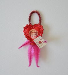 a pink and red heart shaped keychain hanging on a wall