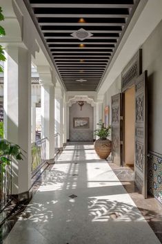 the hallway is lined with potted plants on either side