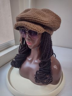 a mannequin head wearing a hat and sunglasses on top of a white table