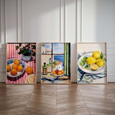 three paintings of lemons and oranges are on display