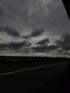 the sky is dark and cloudy as seen from inside a car