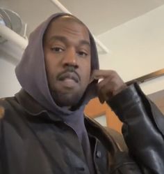 a man wearing a hoodie talking on a cell phone