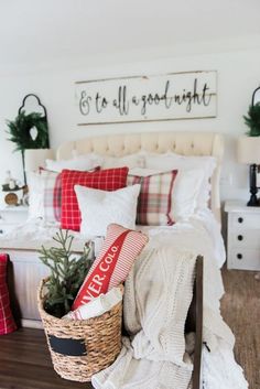 a christmas bedroom decorated for the holidays with red and white plaid bedding, pillows, blankets, and decorations