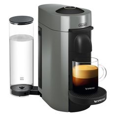 an espresso machine with a cup of coffee next to it on a white background