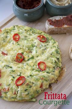 an omelet on a cutting board next to some bread