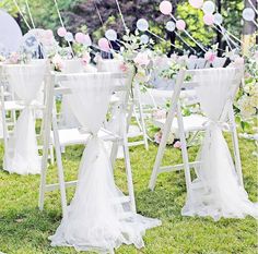 an outdoor wedding set up with white chairs and flowers