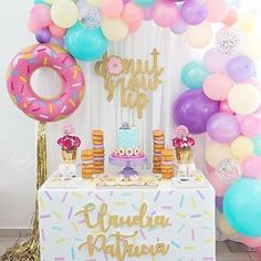 a birthday party with balloons, cake and donuts