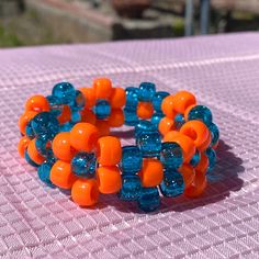 Orange Bangle Bracelet With Colorful Beads, Handmade Plastic Bangle Bracelets, Handmade Round Bead Bracelets, Handmade Plastic Bracelets With Round Beads, Adjustable Orange Bracelet Wristband, Adjustable Orange Wristband Bracelet, Handmade Blue Beaded Plastic Bracelets, Orange Flower Bracelet For Gift, Adjustable Orange Bangle Bracelet