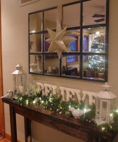 a table with christmas decorations and lights on it in front of a mirror that says merry