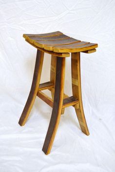 a wooden stool sitting on top of a white sheet