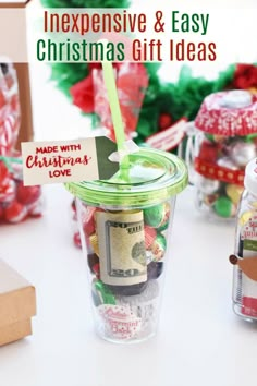 a cup filled with money sitting on top of a table next to other christmas decorations